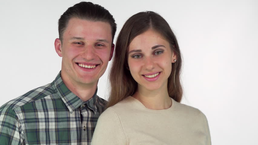 Young man smiling, offering chocolate donut to his beautiful girlfriend