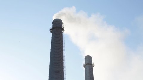 Factory pipes. Smoke comes from factory pipes. Air pollution. Factory pipes against the blue sky. Sunny day.