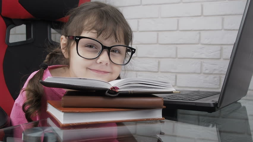 Dropping head. Funny girl with huge glasses dropped her head on stack of books. Smart child with a book.