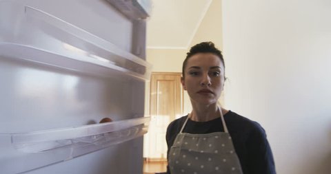 Attractive Woman opens door of an empty refrigerator surprised POV view from inside the fridge and gets disappointed without food in the Kitchen shot on RED camera