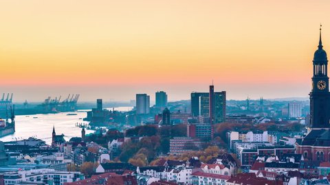 Aerial view of the harbor, St. Michael's Church (German: St. Michaelis) and downtown Hamburg, Germany. 4k UHD time lapse video at dusk with day to night transition.