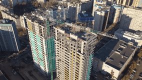Construction site close to living buildings in finished block , two new building and crane aerial video