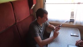 Casual man reading from mobile phone screen while reads sms message traveling on train wagon. slow motion video. Wireless social media internet web on lifestyle public transport concept . train