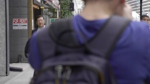 Tokyo, Japan - September 25, 2018: Men in business suits walking along the street in Tokyo,Japan