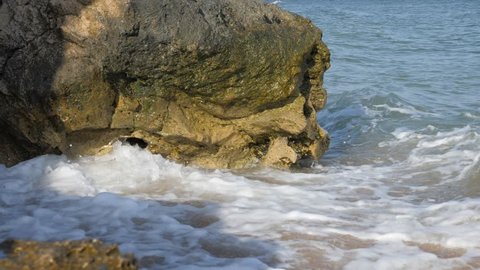 Waves wash the sandy shore. Ridge is broken on the rocks