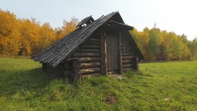 Old. handmade log cabin. standing in ramshackle condition. in an agricultural field in Rural Ukraine. FullHD footage