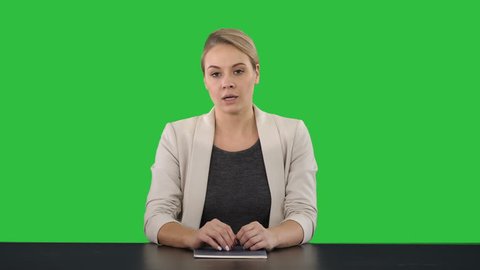 Young beautiful television announcer giving a speach on a Green Screen, Chroma Key.