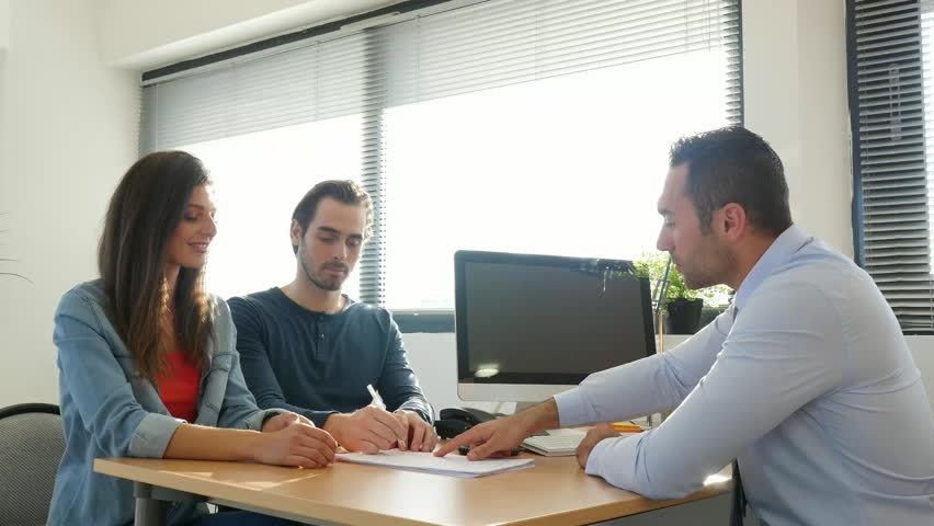 Happy young couple in office with businessman on business buying agreement contract signature
 | Shutterstock HD Video #1020258472