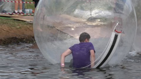 Moscow, Russia - August, 2018: Boy inside the large transparent ball on the water
