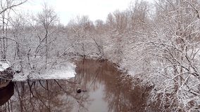 Moving slowly over river through snow covered forest.

