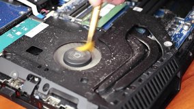 A geek cleans a laptop cooler. Contaminated computer cooling system. Technical support concept. Close up video footage