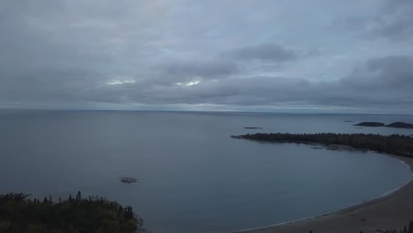 Aerial view of a beautiful beach on the Lake Superior during a vibrant cloudy sunrise. Taken in Terrace Bay, Ontario, Canada.