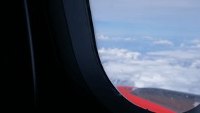 Clouds and sky as seen through window of an aircraft flying, plane window view with blue sky and clouds. Royalty high-quality free stock video footage of view from airplane window sky view on the wing