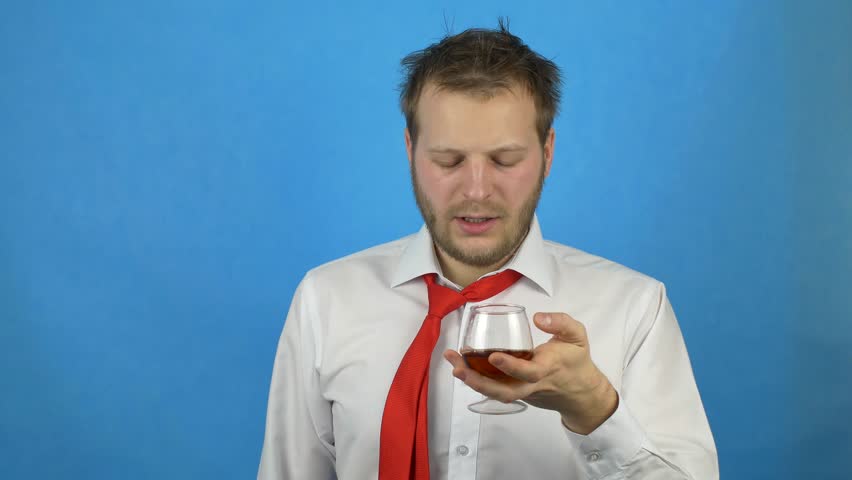 A young man with a beard in a white shirt and tie holds a glass with alcohol and wants to drink, but it is stopped, alcohol encoding, failure against alcohol Royalty-Free Stock Footage #1020293002
