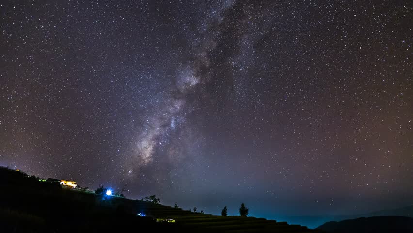 Time lapse of Milky Way Galaxy over hut on paddy rice field  at night sky.