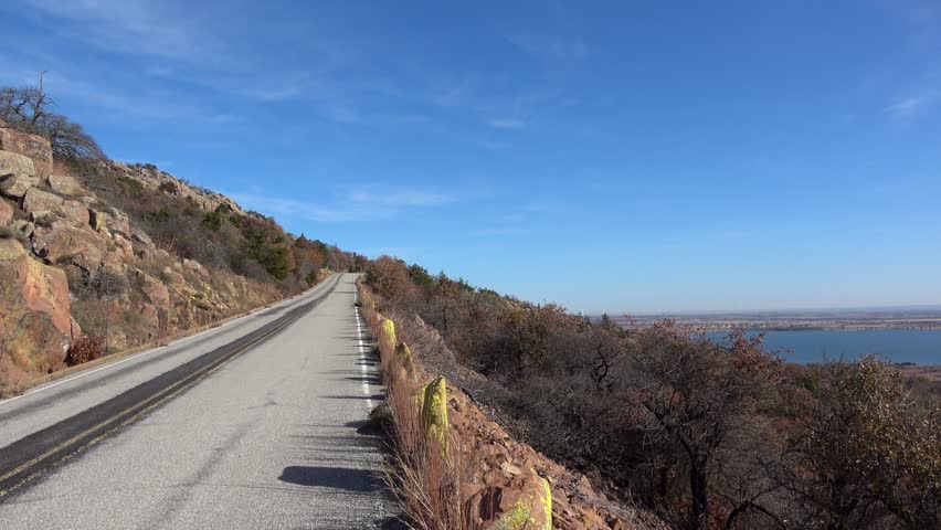 View of beautiful landscape with lake and autumn colors of wild growing trees and brush. View from Wichita Mountains.