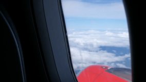 Clouds and sky as seen through window of an aircraft flying, plane window view with blue sky and clouds. Royalty high-quality free stock video footage of view from airplane window sky view on the wing