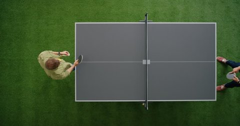 two young men playing ping pong game enjoying competitive sport in modern recreational workspace top view