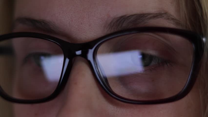 Young business woman in glasses working on the laptop. Close up. The image of computer screen in the glasess.