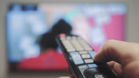 man hand holding the TV remote control and turn off smart tv. Channel lifestyle surfing . Close up mans hand holding TV remote control and changing TV channels. blurred background