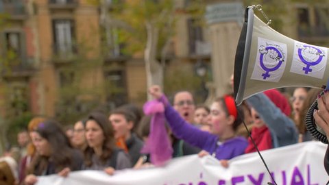 Barcelona, Spain. November 25th 2018: Megaphone Close Up with feminist stickers. Defocused women on the frame with arms up. Feminist Activists in a Demonstration. March for the Day of Nonviolence