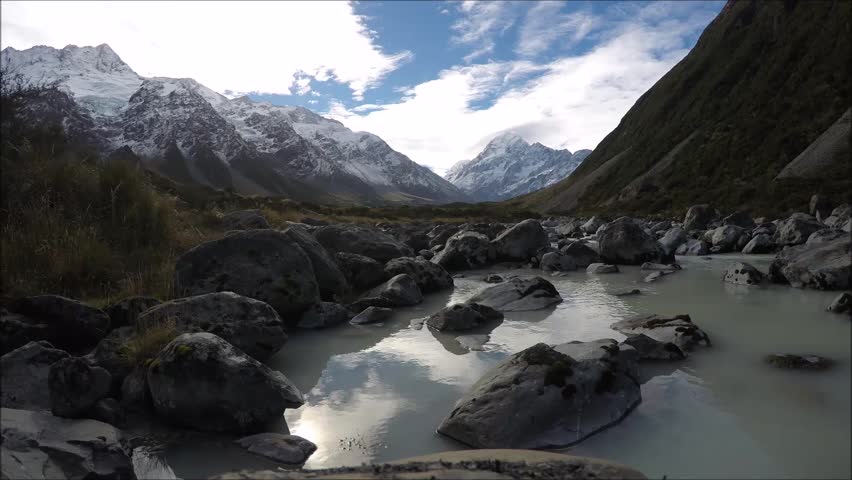 Timelapse mountain video from Hooker Valley walking track, Aoraki/Mount Cook National Park, South Island, New Zealand. Snow covered mountains, blue sky, moving clouds. Must visit in NZ.