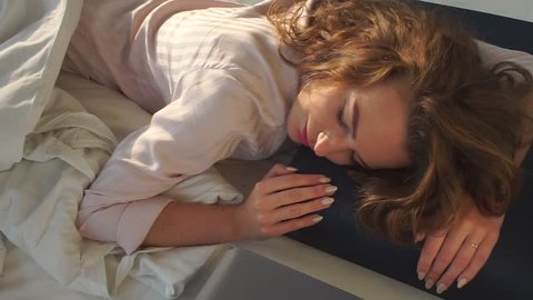 Girl is lying on dark pillow sleeping. Practice relaxing bedtime ritual. Sleep schedule. Nap. Sleep on comfortable mattress and pillows. Insomnia is a common sleep problem for adults.