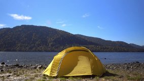 Altai. Two videos in one. The yellow tent costs on the bank of the mountain lake.