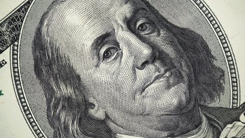Benjamin Franklin face on US 100 dollar bill rotating, money close up. 4K UHD video footage