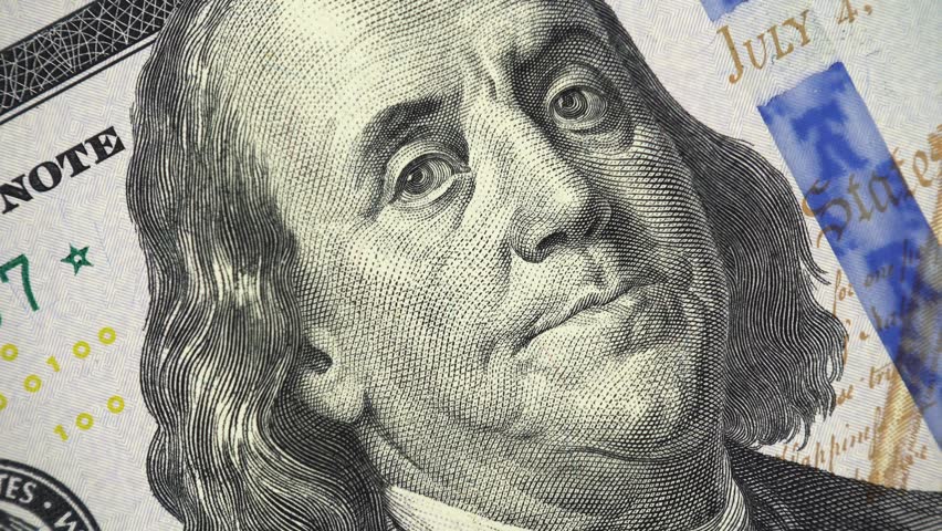 Benjamin Franklin face on new US 100 dollar bill rotating, money close up. 