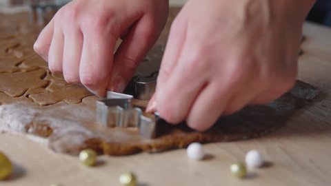 Cutting out gingerbread men cookies, 4k video, preparing dough, gingerbread preparing, woman cooking, hands