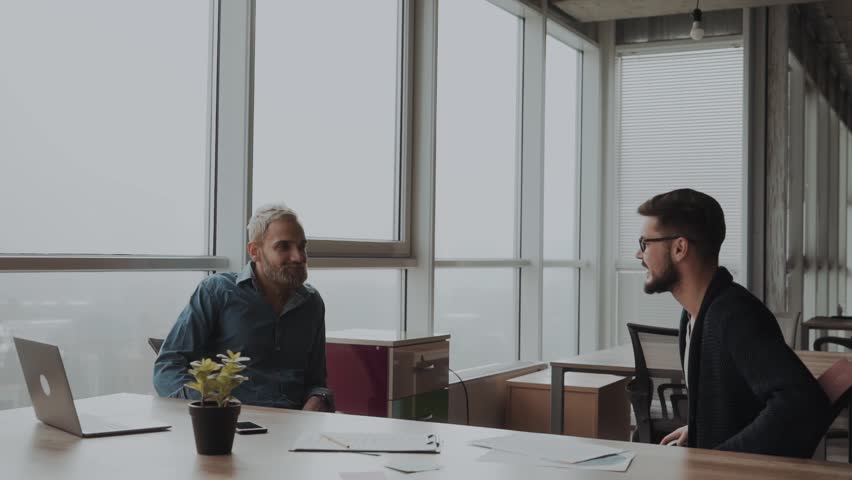Handshake, closing the deal, young two men professionals in the nice office next to the window. Royalty-Free Stock Footage #1020358369