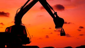 Construction Video At construction site The silhouette excavator is digging ground and lifting a large mortar with engineering and construction workers to help with colorful sunset