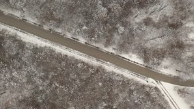Pedestrian walks on snowed forest road 4K aerial footage