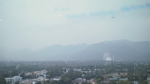 Beautiful city of Islamabad, surrounded by green mountains, and Faisal mosque can been seen