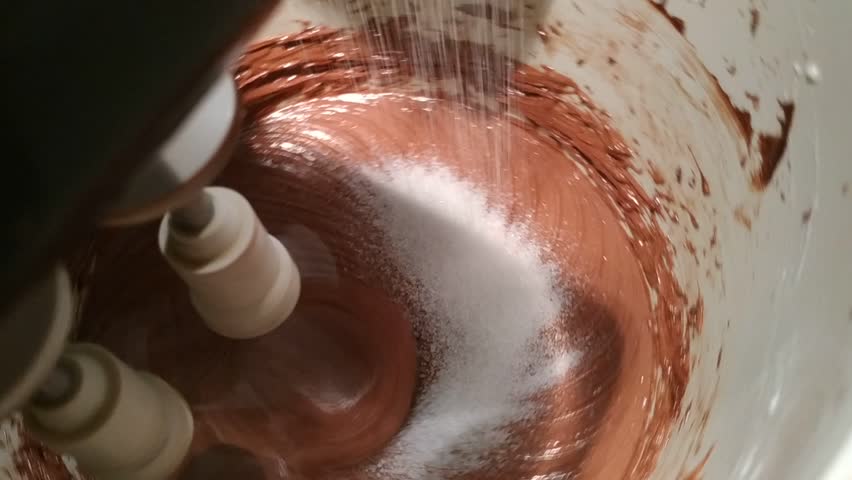Preparation of the sacher torte, the whisk whips mix the ingredients as they are poured into the container. Drawings are formed on the mixture. | Shutterstock HD Video #1020396874