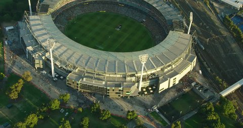 Melbourne - March 2018: Aerial view at sunset Melbourne Cricket Ground sports stadium with floodlights alongside railway tracks Yarra Park Victoria Australia