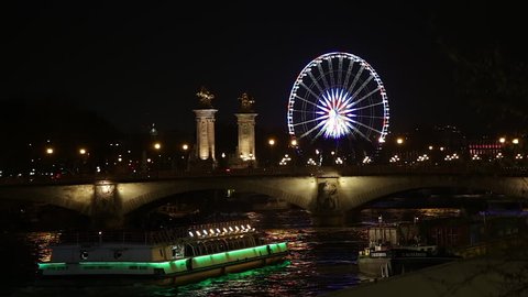 Paris, France - April 2018 : Pont Alexandre III bridge at night in Paris France with the Ferris wheel of la Place de la Concorde in the background