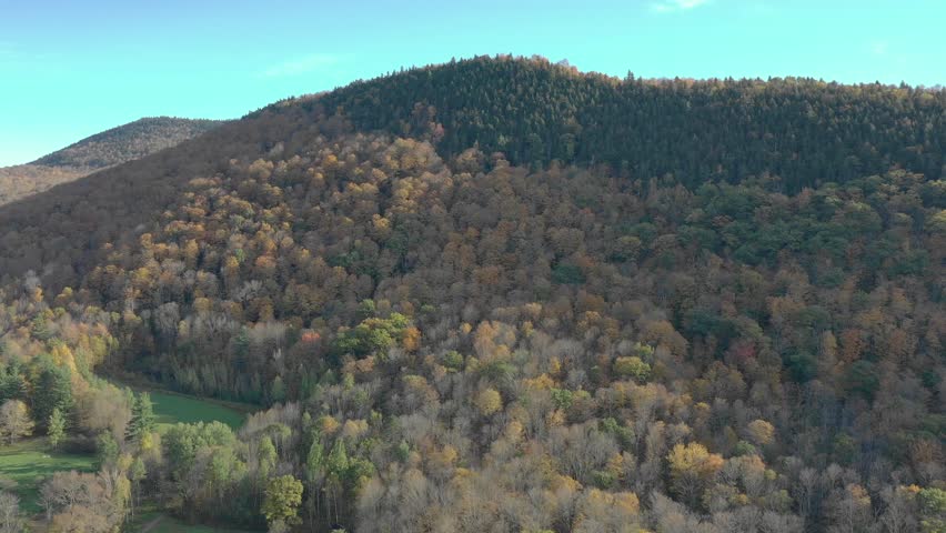 Autumn aerial view surveys Mohonk Mountain near New Paltz with dense colorful woodland and rounded New York ridges, 2018.