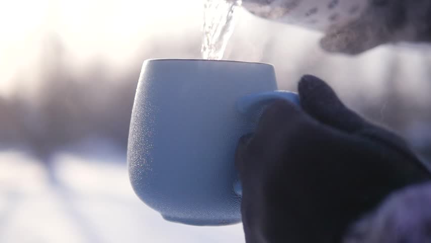 Thermos with a hot drink. Poured into a cup, there is a pair.