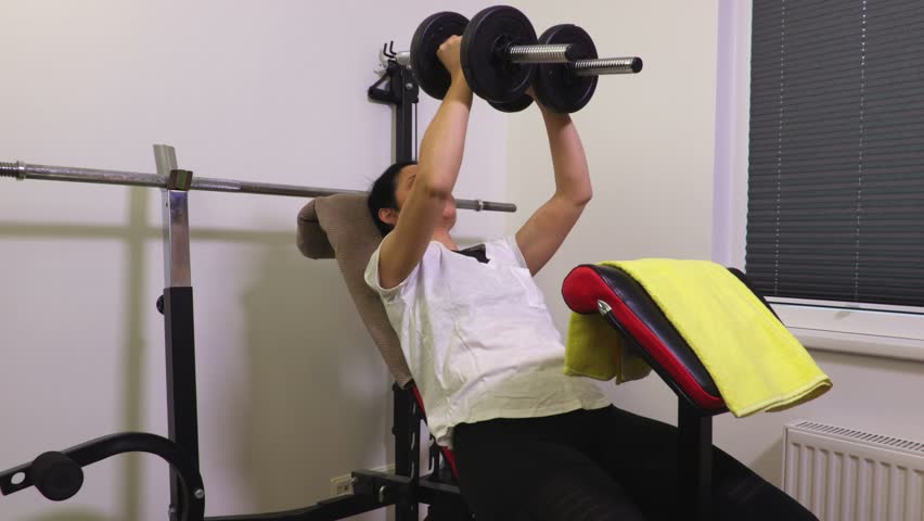 Woman on gym bench doing exercises