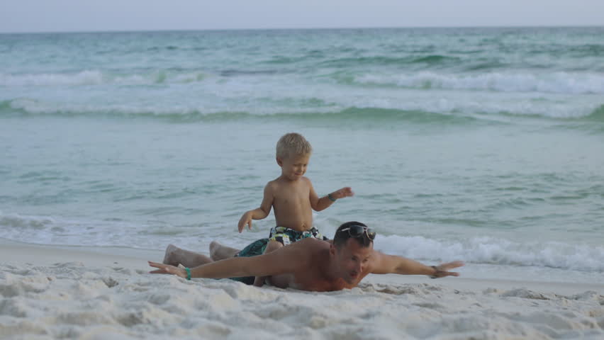 Young father and his little son have fun playing at the beach 4k