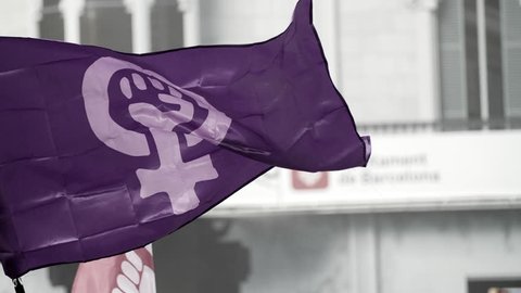 Barcelona, Spain. November 25th 2018: Feminist Flag waving in front of an urban background. Feminist Activists in a Demonstration. March for the International Day of Nonviolence against Women 