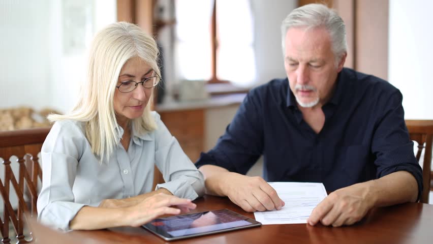 Senior couple working out their bills at home  | Shutterstock HD Video #1020423853