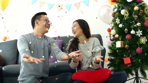 Young asian couple celebrating in Christmas party at home,slow motion.
