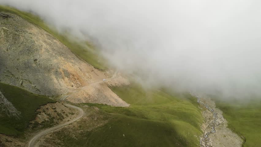 4k drone footage of dense fog rolling in over a green mountain in the region of North Caucasus, Russia Evergreen Forest Overview - Tops of Tall Green Trees with Dense Fog Rolling