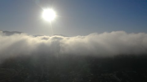 Aerial view of low fog over mountains in San Diego during sunrise