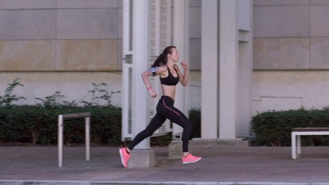 Athletic fitness woman running in urban city RED DRAGON