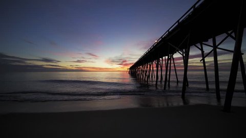 kure beach fishing pier right before sunrise on a calm morning