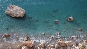 Beautiful morning seascape. Aerial top view of charming calm blue sea water, huge rocks and stones. Scenic summer marine background. Real time full hd video footage.